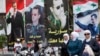Ahead of Tuesday's election, women walk past election posters of Syria's President Bashar al-Assad along a street in Damascus, Syria, June 2, 2014. 