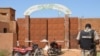 Un gendarme nigérien se tient près des motocyclettes calcinées utilisées par les assaillants, devant la prison de Koutoukale, près de Niamey, suite à une attaque le 17 octobre 2016.