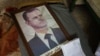 Retrato do Presidente sírio Bashar al-Assad com a moldura partida, nas instalações do Departamento de Segurança Política nos arredores da cidade central de Hama.