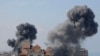 TOPSHOT - Smoke billows from residential buildings following Israeli airstrikes in Gaza City on October 7, 2023.
