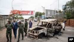 Border officials inspect a burnt-out Mozambican border patrol vehicle at the border crossing in Lebombo, South Africa, Nov. 7, 2024. 