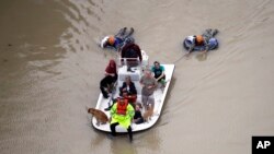 Evacuados se abren paso entre las inundaciones cerca de Addicks Reservoir mientras las aguas desbordadas por Harvey crecen el martes, 29 de agosto de 2017.
