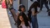 Students use their cellphones as they leave for the day the Ramon C. Cortines School of Visual and Performing Arts High School in downtown Los Angeles, Aug. 13, 2024.