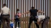 Agentes de la Patrulla Fronteriza de Estados Unidos revisan y registran a los migrantes de Guatemala después de que se entregaran a las autoridades en la frontera entre Estados Unidos y México, el 12 de mayo de 2021 en Yuma, EE. UU.