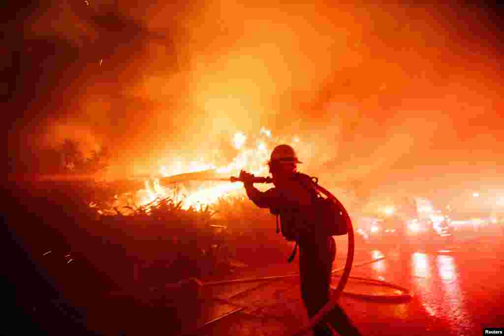 Um bombeiro luta contra o incêndio de Palisades enquanto este arde durante uma tempestade de vento no lado oeste de Los Angeles, Califórnia, a 7 de janeiro de 2025.