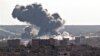Smoke rises over the Syrian city of Kobani, following a US led coalition airstrike, seen from outside Suruc, on the Turkey-Syria border, Nov. 10, 2014. 