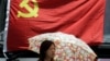在上海，一名妇女在中共党旗下走过。中共有8000多万党员