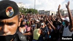 La gente reacciona durante las protestas contra y en apoyo del gobierno, en medio del brote de la enfermedad del coronavirus (COVID-19), en La Habana, Cuba, el 11 de julio de 2021.