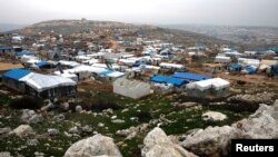 FILE - Makeshift shelters of internally displaced Syrians are seen from a hill top in Sarmada, Idlib province, Syria, Feb. 28, 2020. 
